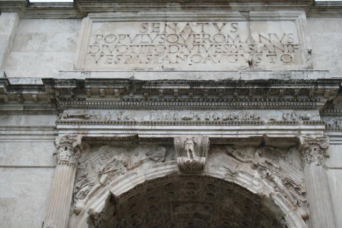 Iscrizione dedicatoria dell'arco con il piccolo fregio della processione, le Vittorie, Honos e Virtus