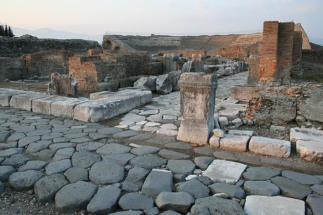 La via Appia che attraversa le rovine di Minturnae (sullo sfondo il teatro romano)